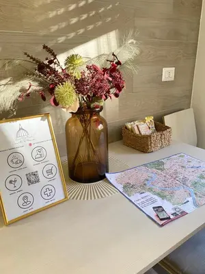 a table with a vase with flowers and a map at San Pietro Sweet RHome in Rome