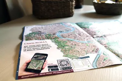 a book with a cell phone on top of a map at San Pietro Sweet RHome in Rome