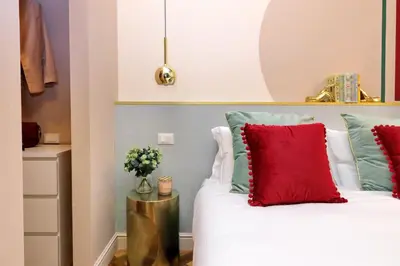 a bedroom with a bed with red and green pillows at YCH-Bright Suite Navona in Rome