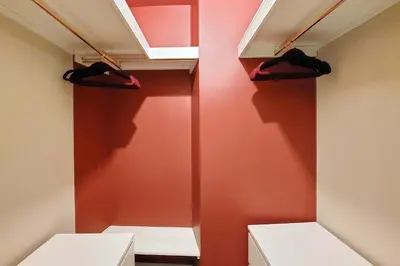 a walk in closet with red walls and hangers at YCH-Bright Suite Navona in Rome