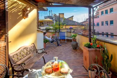 a patio with a table and a bench on a balcony at Angel's Terrace in Rome