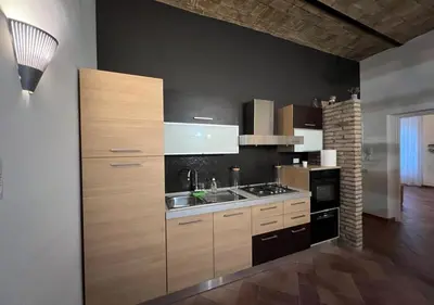 a kitchen with wooden cabinets and a sink and a stove at StarHome San Paolo in Rome