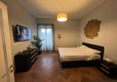 a bedroom with a bed and a flat screen tv at StarHome San Paolo in Rome