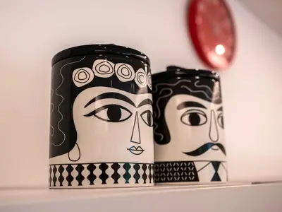 two black and white mugs on a shelf with a clock at Majo Suite in Rome