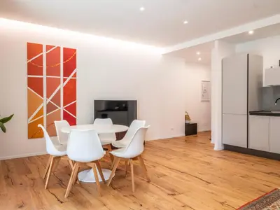 a dining room with a table and white chairs at Majo Suite in Rome