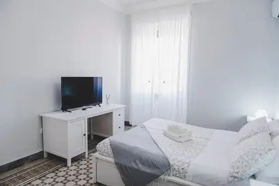 a white bedroom with a bed and a tv at La Casa di Klaudia in Rome