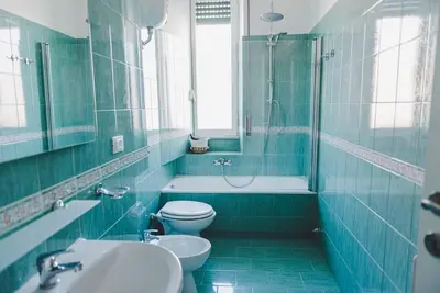 a blue bathroom with a toilet and a sink at La Casa di Klaudia in Rome