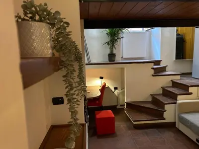a room with a stairway with a person standing in a room at Garden House Trastevere in Rome