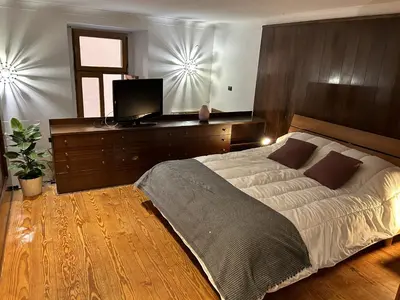a bedroom with a large bed and a flat screen tv at Garden House Trastevere in Rome