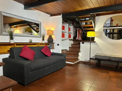 a living room with a couch and a staircase at Garden House Trastevere in Rome
