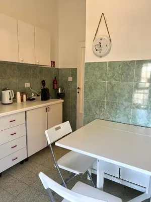 a kitchen with a table and chairs and a clock on the wall at Eufonia Gemelli Apartment in Rome