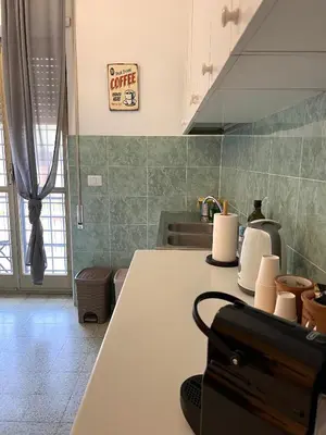 a kitchen with a table and a sink and a counter at Eufonia Gemelli Apartment in Rome