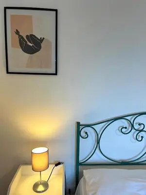 a bedroom with a bed and a lamp on a night stand at Eufonia Gemelli Apartment in Rome