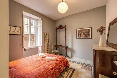 a bedroom with a bed and a table and a window at Monti Coliseum 2nd floor 3 bedroom in Rome