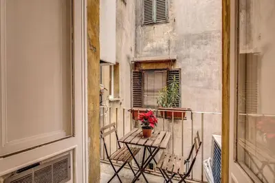 a balcony with a table with a potted plant on it at Monti Coliseum 2nd floor 3 bedroom in Rome