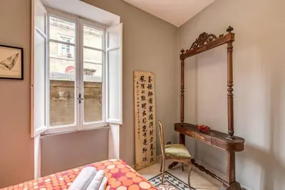 a bedroom with a bed and a desk and a window at Monti Coliseum 2nd floor 3 bedroom in Rome