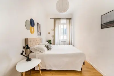a white bedroom with a bed and a lamp at Nora's Home, Charmy Apt in the Heart of Trastevere in Rome
