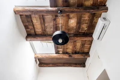 a ceiling made out of reclaimed wood with a black ceiling light at Nora's Home, Charmy Apt in the Heart of Trastevere in Rome