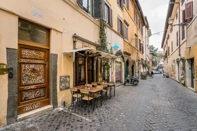 an alley with tables and chairs on a street at Nora's Home, Charmy Apt in the Heart of Trastevere in Rome