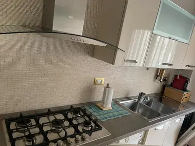 a kitchen counter with a sink and a stove at Casa Alessi in Rome elegant, spacious and comfortable apartment in Rome