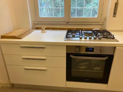 a kitchen with a stove top oven next to a window at FAIROME Apartment Farnesina in Rome