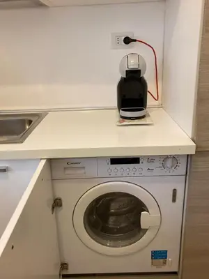 a washing machine in a kitchen with a counter at FAIROME Apartment Farnesina in Rome