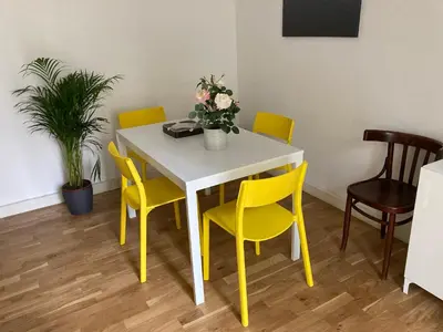 a yellow dining room table and chairs with flowers on it at FAIROME Apartment Farnesina in Rome