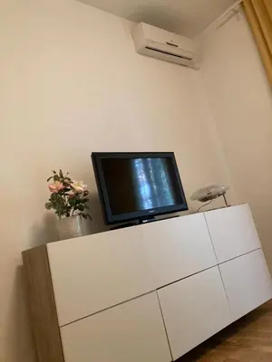 a tv sitting on top of a white cabinet at FAIROME Apartment Farnesina in Rome