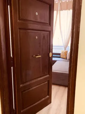 a wooden door in a room with a couch at A casa di Clara in Rome