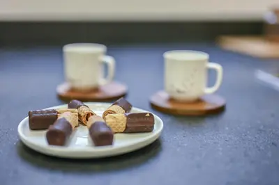 a plate of chocolate desserts and two coffee cups at Suite 109 in Rome