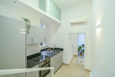 a kitchen with white cabinets and a sink at Suite 109 in Rome