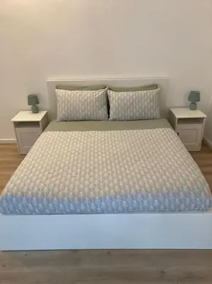 a large bed with two nightstands and two tables at Casetta Marconi Trentotto in Rome