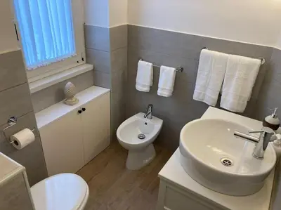 a bathroom with a white sink and a toilet at Casetta Marconi Trentotto in Rome