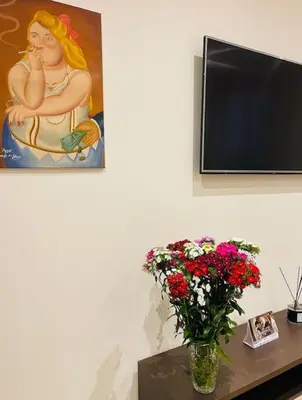 a vase of flowers on a table with a painting at Attico Loft con terrazza Vía dei Coronari - Roma in Rome