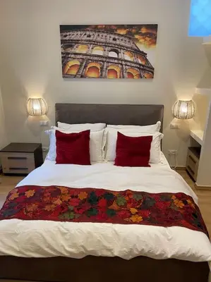 a bedroom with a bed with two red pillows at Attico Loft con terrazza Vía dei Coronari - Roma in Rome