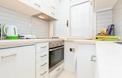 a white kitchen with white cabinets and a sink at Nice Apartment with Balcon in Rome