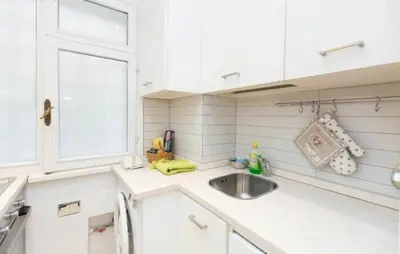 a white kitchen with a sink and a window at Nice Apartment with Balcon in Rome