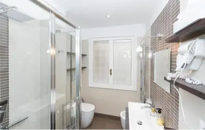a bathroom with a toilet and a glass shower at Nice Apartment with Balcon in Rome