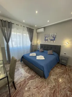 a bedroom with a large blue bed and a table at Henry Suite in Rome