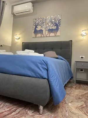 a bedroom with a bed with a blue blanket at Henry Suite in Rome