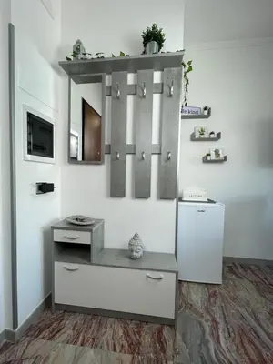 a kitchen with a refrigerator and a shelf on the wall at Henry Suite in Rome