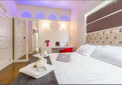 a bedroom with a white bed with a laptop on it at Piazza Venezia Luxury Suite in Rome