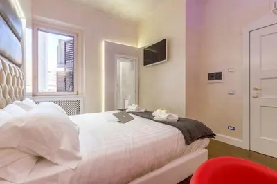 a bedroom with a white bed with a laptop on it at Piazza Venezia Luxury Suite in Rome