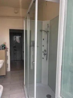 a bathroom with a shower with a glass door at Casa di Mochi in Rome