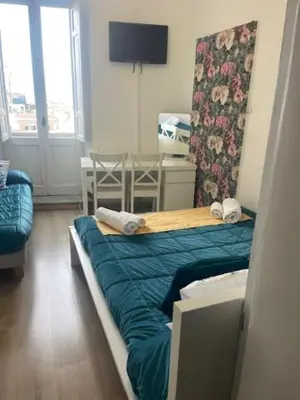 a bedroom with a bed with a blue comforter at Casa di Mochi in Rome
