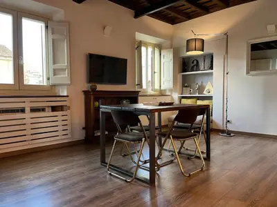 a kitchen with a table and chairs and a television at Colosseo Suite in Rome