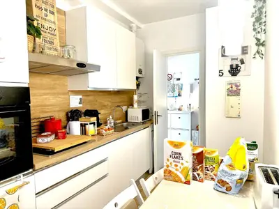 a kitchen with white cabinets and a table with food on it at Gemelli-San Pietro-Trastevere-casa con posto auto in Rome