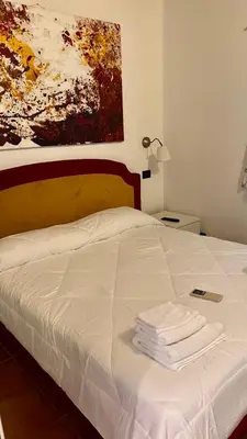 a bed with towels on it with a painting on the wall at Villette Aldobrandeschi Urban Oasis Vacation Homes in Rome