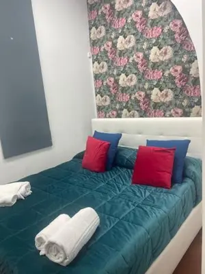 a green bed with red and blue pillows on it at Appartamento int 1 in Rome