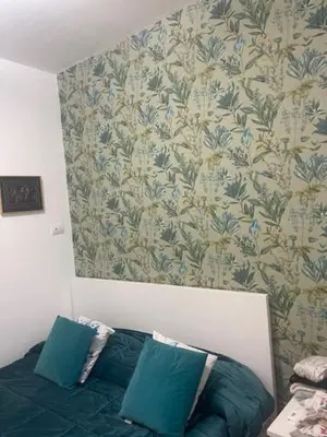 a bedroom with a bed with blue pillows and a wallpaper at Appartamento int 1 in Rome